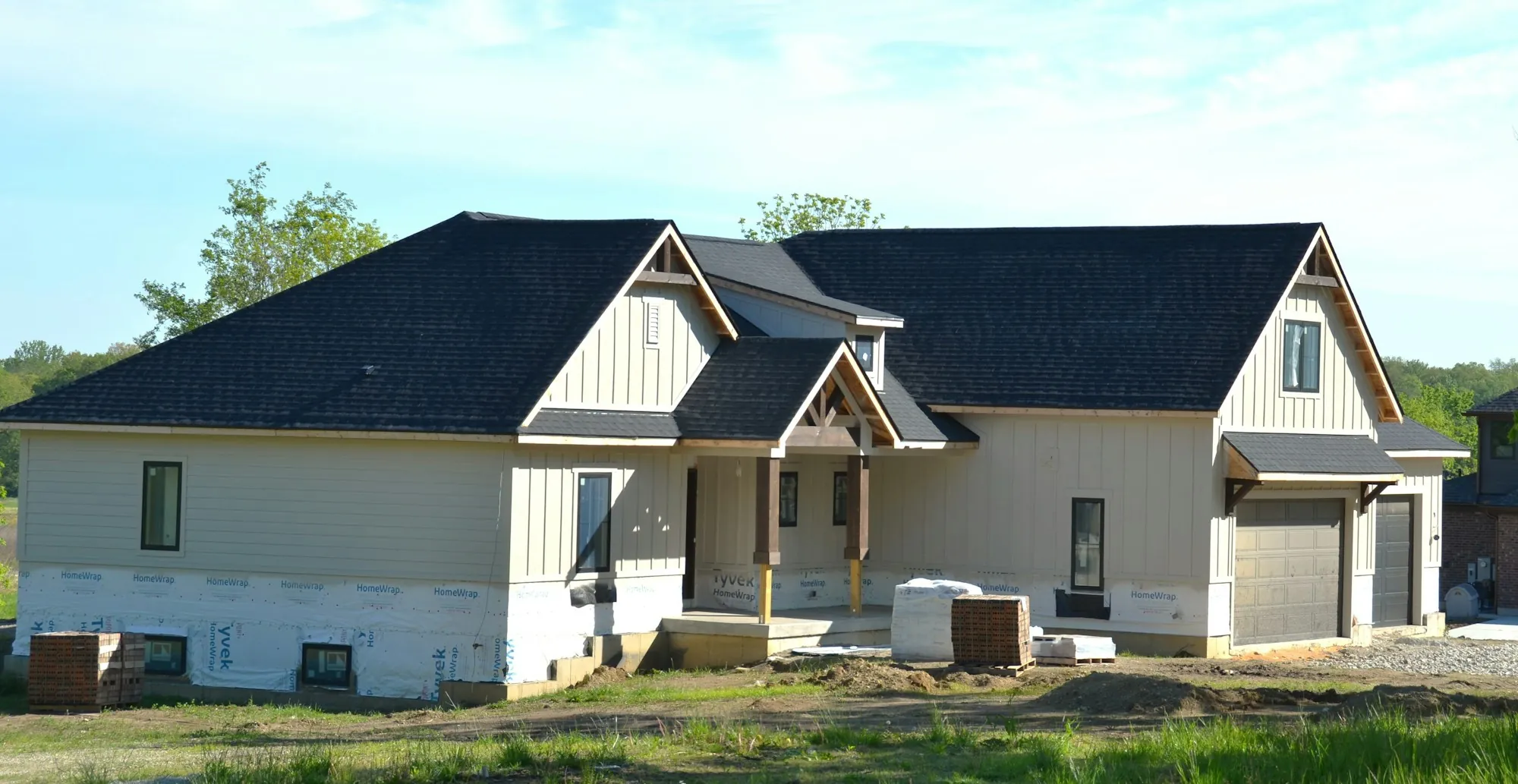 New two-story home with a dark shingle roof under construction